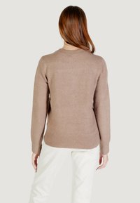 Maglione color marrone chiaro realizzato in tessuto morbido, con scollo rotondo, polsini e orlo a coste, caratterizzato da un design semplice e pulito.