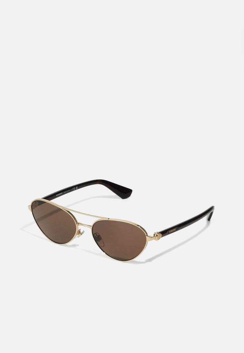 Ochelari de soare de formă ovală, cu lentile maro, cadru din metal aurit și temple din plastic negru. Prezintă un design elegant, minim, fără modele vizibile.