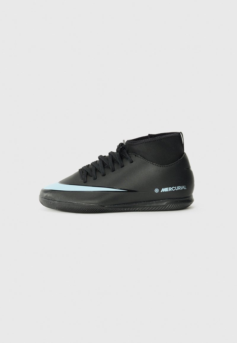 Chaussures de football noires avec un design montante, présentant une rayure d'accent bleu clair, une surface texturée et une semelle extérieure en caoutchouc à motifs.