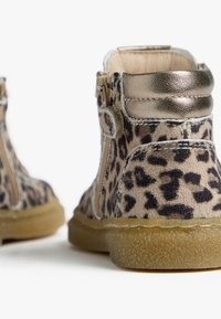 Stivali in pelle scamosciata con stampa leopardata, con un elegante accento dorato sul tacco, dotati di una zip laterale e di una suola in gomma strutturata.