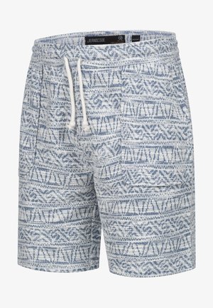 Pantaloni corti blu a fantasia realizzati in tessuto testurizzato. Presentano una vita con cordino e design geometrici in diverse tonalità di blu su uno sfondo bianco.