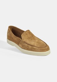 Braune Wildleder Slipper mit runder Spitze, genähten Details und einer kontrastierenden hellen Gummisohle. Texturierte Oberfläche und lässiges Design.