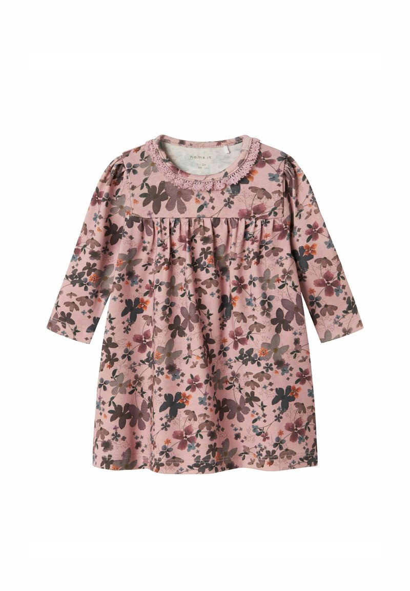 Pitkähihainen mekko pehmeästä vaaleanpunaisesta puuvillasta, jossa on kukkakuosi tummissa ja vaaleissa väreissä. Mekossa on kootut vyötärö ja pitsireunainen kaula-aukko.