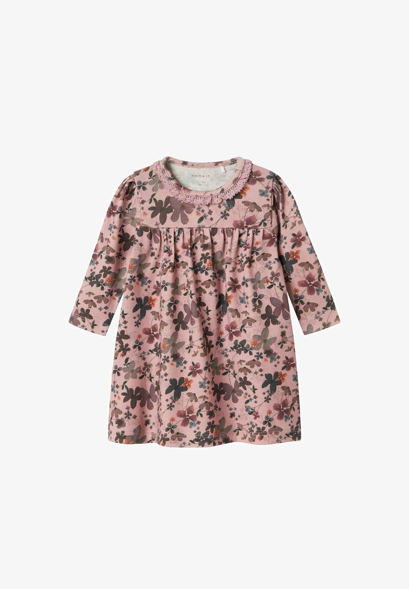 Pitkähihainen mekko pehmeästä vaaleanpunaisesta puuvillasta, jossa on kukkakuosi tummissa ja vaaleissa väreissä. Mekossa on kootut vyötärö ja pitsireunainen kaula-aukko.