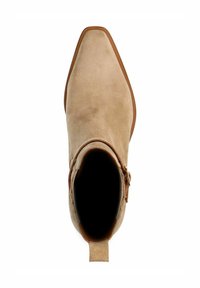 Stivaletto in suede beige con punta a punta, cuciture marroni a contrasto, dettaglio con fibbia laterale e tacco di altezza media. Interno cavo visibile.