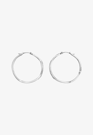 Sølvfarvede hoops øreringe med et snoet design og små indlagte klare krystaller langs den ydre kurve, vist åbent.