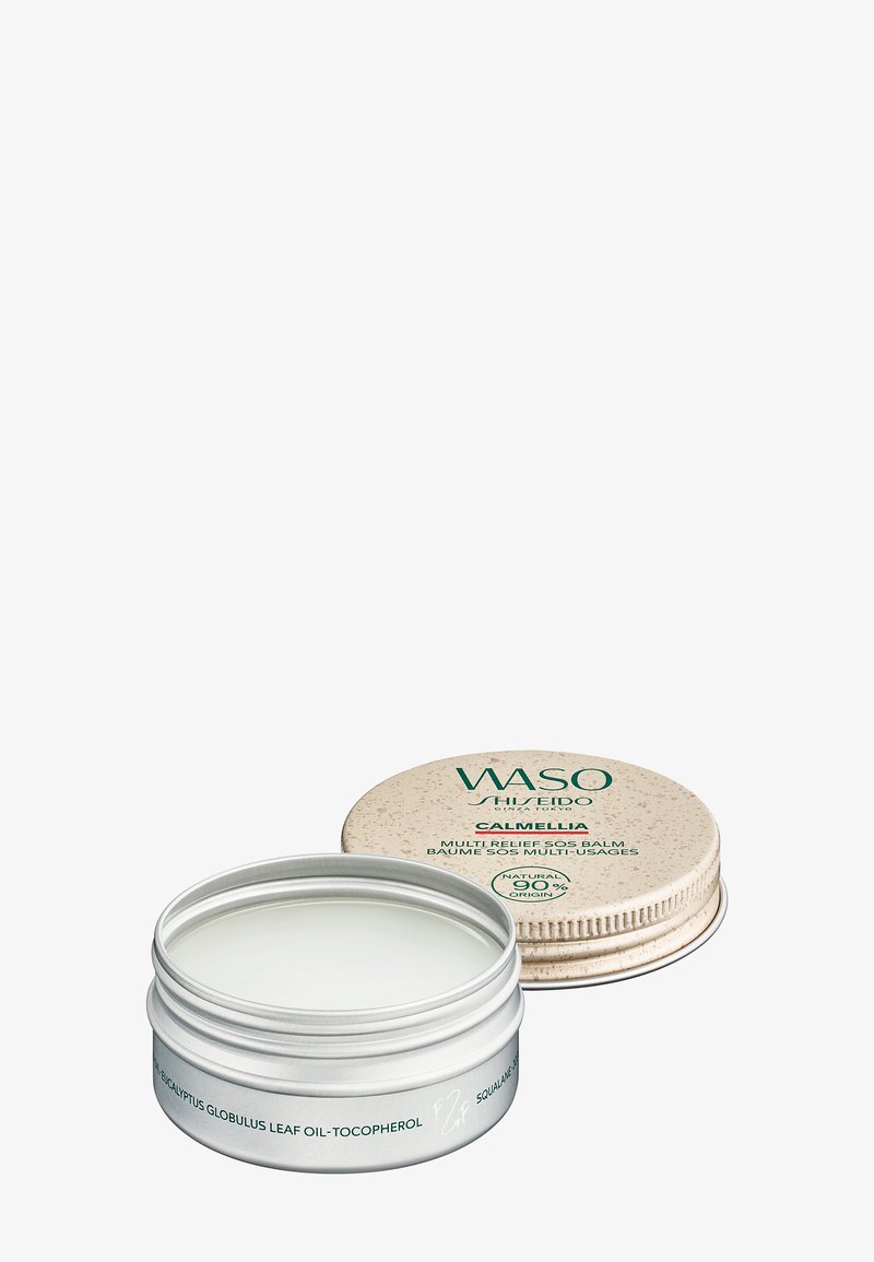 Geöffneter silberner Behälter von WASO Shiseido Calmellia Multi-Relief SOS-Balsam mit beigem Deckel daneben auf weißem Hintergrund.