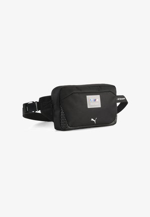 Schwarze Puma-Gürteltasche mit BMW Motorsport-Logo, Reißverschluss, verstellbarem Gurt und kleinen gepunkteten Seitenakzenten vor weißem Hintergrund.