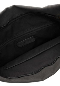 Mustast kangast koti sisemus, kus on lukk-tasku ja silt, millel on pealmise sahtli sees embosseeritud "EMILY & NOAH".