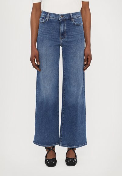 Weite blaue Jeans mit hoher Taille, Vorderseitentaschen und leichtem Verblassen. Der Stoff zeigt eine klassische Denim-Textur.