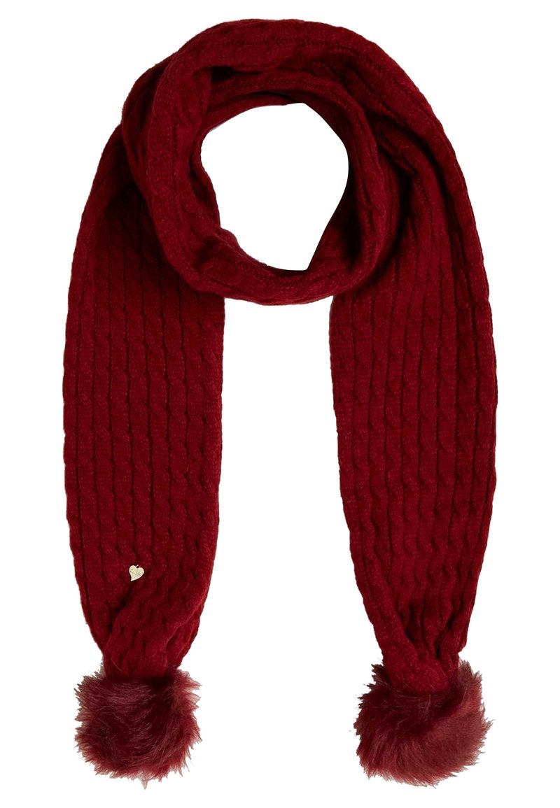 Écharpe tricotée rouge foncé avec motif torsadé, pompons en fausse fourrure aux deux extrémités, et une petite étiquette métallique en forme de cœur sur un côté.