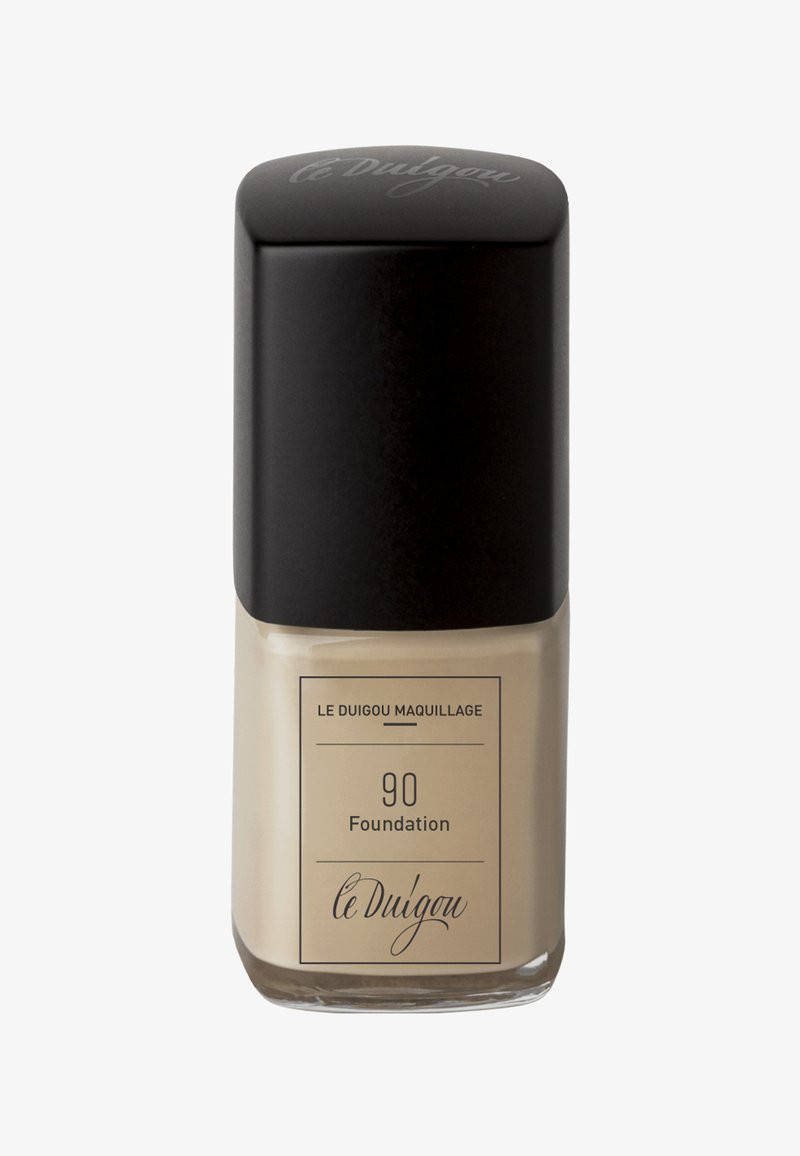 Die Foundation-Flasche hat eine rechteckige Form mit einem mattschwarzen Deckel, einem klaren Glasboden und ist mit "90 Foundation" in eleganter Schrift beschriftet.