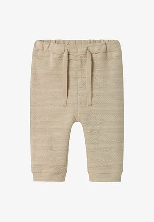 Beige knitted pants with a textured pattern. Features a stretchy waistband, drawstring, and tapered cuffs. Soft, lightweight material.