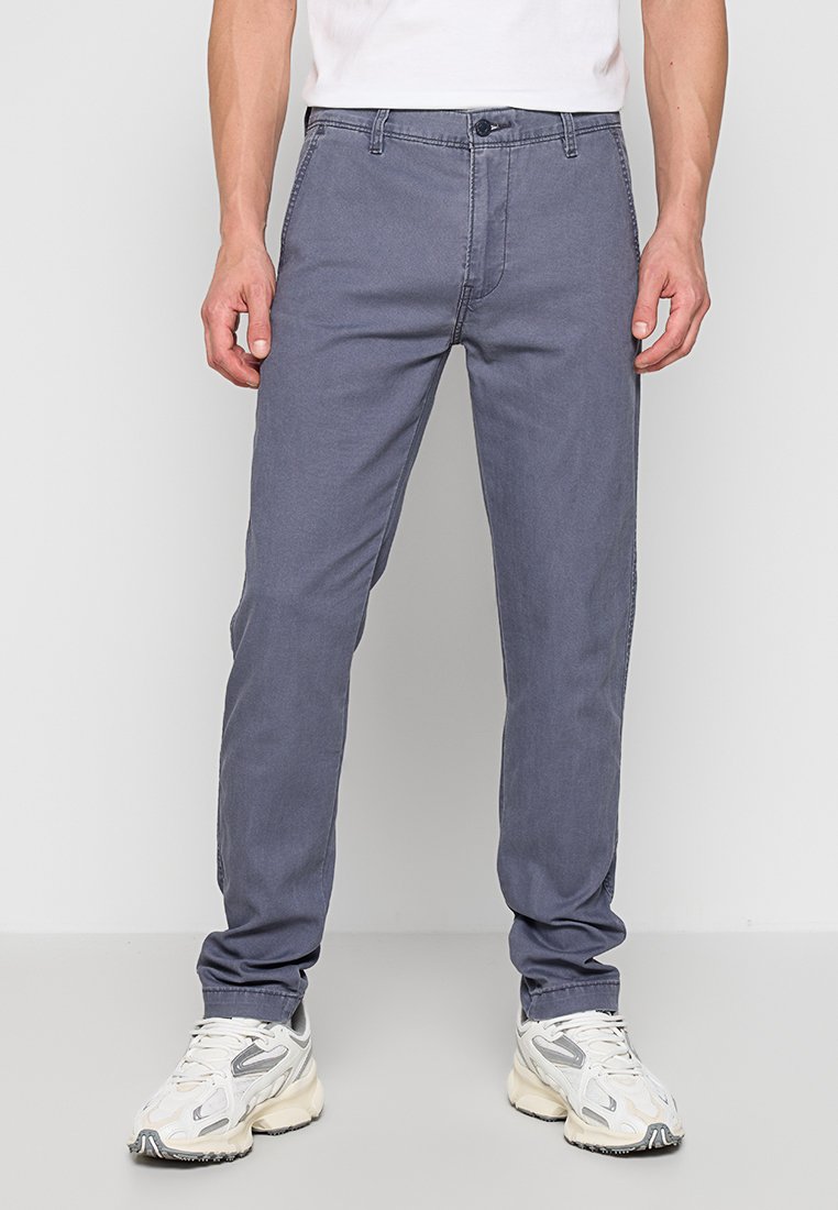 Pantalones de algodón grises con un corte recto, que cuentan con cinco bolsillos, una bragueta con botón y detalles de costura sutiles.