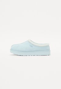 Svijetloplave velur slip-on cipele s teksturiranim ovratnikom u krem boji, gumenom potplatu i "UGG" logotipom sa strane.