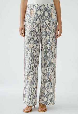 Weite Hosen im Schlangenmuster mit einem Creme-Hintergrund und Akzenten in Marineblau, Grau und Orange, aus leichtem Stoff gefertigt.