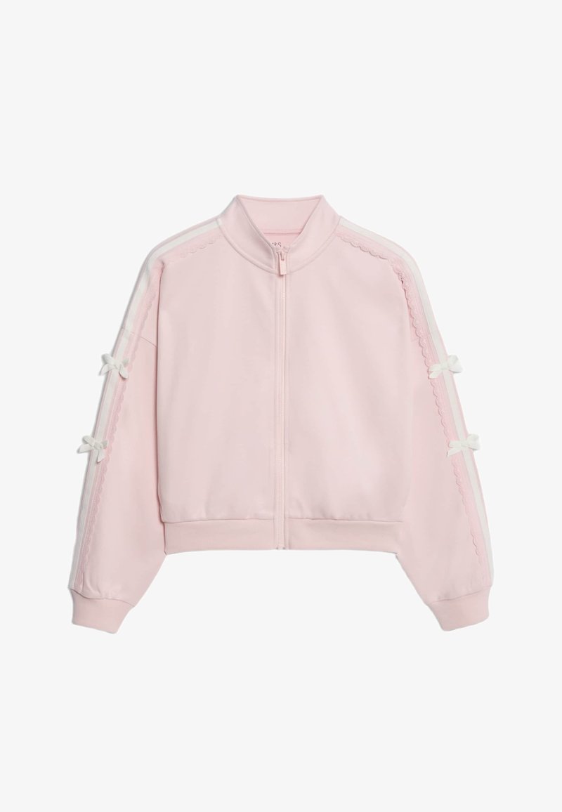 Giacca cropped rosa con colletto alto, chiusura con zip e strisce bianche ai lati. Presenta dettagli a fiocco e bordi scallopati sulle maniche. Texture morbida.