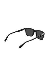 Ochelari de soare negri cu un finisaj mat, rame rectangulare, lentile întunecate și brațe negre elegante, cu o bandă de accent albă.