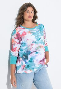 Mehrfarbiger Sweatshirt mit einem abstrakten Muster in Blau-, Pink- und Weißtönen. Lange Ärmel mit einem gerippten türkisfarbenen Bündchen und grafischem Detail.