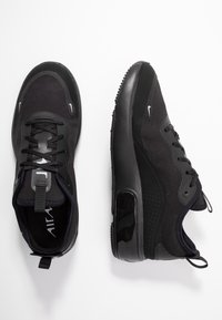 Scarpe sportive nere con tomaia in tessuto e suola in gomma lucida. Design con lacci, linguetta per il calzare e dettagli logo discreti.