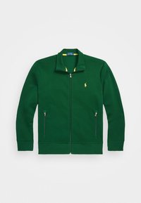 Grön zip-up tröja i bomullsblandning. Har hög krage, gul foder och två sidofickor med dragkedja. Liten logotyp på bröstet.