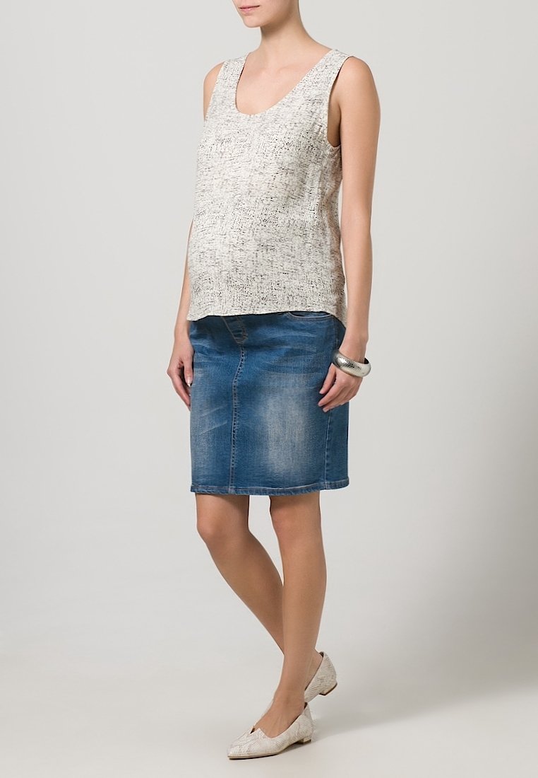 Maternitní top bez rukávů v světle šedém texturovaném materiálu; spojený s modrou džínsovou pouzdrovou sukní. Nosené s plochými, světle zbarvenými botami.