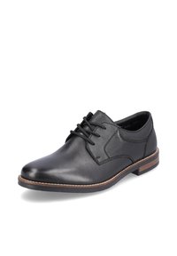 Chaussure de ville en cuir noir avec un laçage, bout arrondi et accents de semelle marron contrastants. Caractérisée par une texture lisse et un design minimaliste.