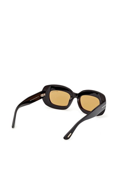Schwarze rechteckige Sonnenbrille mit dicken Rahmen und bernsteinfarben getönten Gläsern, die auf einer weißen Oberfläche liegen.