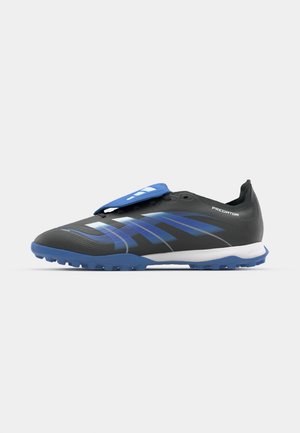 Sportliche Schuhe mit einem schwarzen Synthetik-Obermaterial, blauen Akzenten, strukturiertem Design und einer flachen blauen Laufsohle. Mit einem blauen Riemen auf der Zunge.