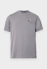 Γκρίζο βαμβακερό T-shirt με κωνικό λαιμό και κοντά μανίκια. Διαθέτει ένα μαύρο και άσπρο ραμμένο λογότυπο στην αριστερή πλευρά του στήθους. Λείο, χαλαρό σχέδιο.