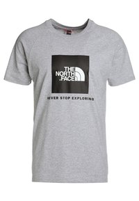 Camiseta de algodón gris con mangas cortas, cuello redondo y un cuadrado gráfico negro con el texto "NUNCA DEJES DE EXPLORAR" debajo.