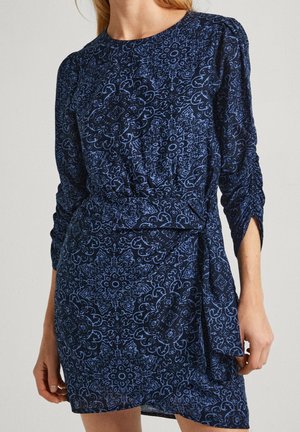 Laivaston mekko pitkähihaisilla, vyötäröllä vyö ja vaaleansinisessä kukkakuosissa. Valmistettu pehmeästä kankaasta, jossa on sileä pinta.