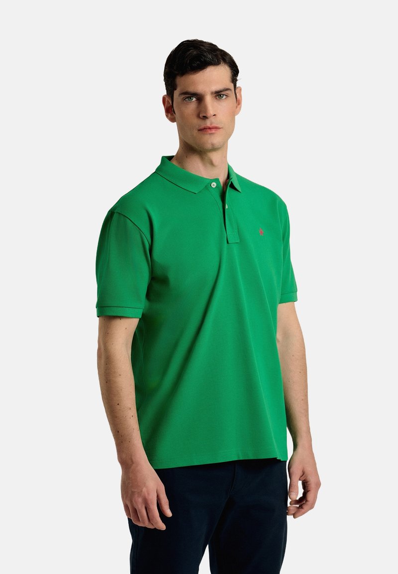 Camisa polo verde con cuello, de mangas cortas y un pequeño logo bordado en el pecho. Fabricada con una tela suave y transpirable.