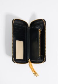 Billetera de cuero negro con cremallera dorada, múltiples ranuras para tarjetas, una ventana transparente para identificación y un bolsillo con cremallera; presenta un acento de borla naranja.