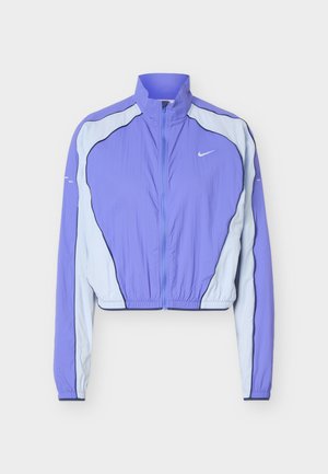 Πανωφόρι αθλητικό με φερμουάρ Nike σε μωβ και ανοιχτό μπλε, με ψηλό γιακά και ελαστική μέση, απλωμένο επίπεδα σε λευκό φόντο.