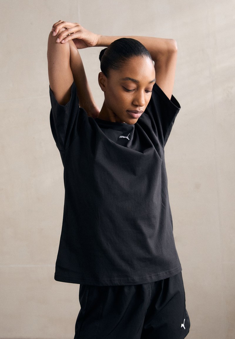 Black cotton T-shirt with a relaxed fit, crew neck, and short sleeves. Features a subtle white logo on the chest.
