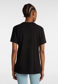 T-shirt in cotone nero con maniche corte e collo rotondo, caratterizzato da una texture liscia e una vestibilità rilassata. Senza loghi o motivi visibili.