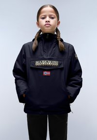 Giacca nera impermeabile con colletto alto, tasca frontale con logo "Napapijri" e patch della bandiera norvegese. Texture liscia, vestibilità rilassata.