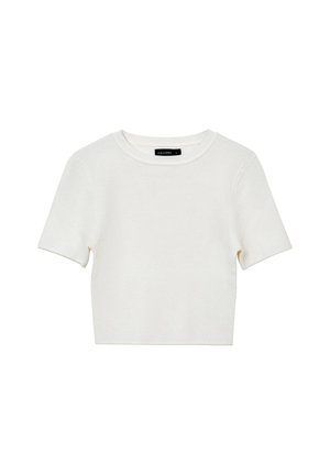 Pull court en tricot à manches courtes blanches avec col rond et étiquette noire visible à l'intérieur du col.