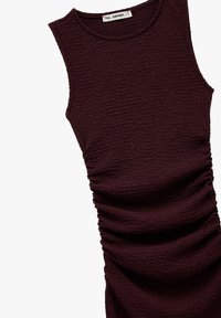 Robe sans manches bordeaux en tissu texturé, avec des détails froncés sur le côté et un col rond.