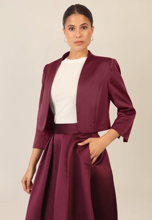 Burgunderfarbene, kurz geschnittene Jacke mit Dreiviertelärmeln, kombiniert mit einem passenden Rock mit Falten, gefertigt aus glattem, strukturiertem Stoff.