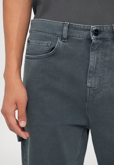 Jeans in denim grigio con una vestibilità dritta, caratterizzati da un design a cinque tasche e una chiusura con bottone. Il tessuto ha una finitura morbida e testurizzata.