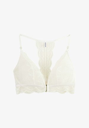 Bralette en dentelle blanche avec bretelles réglables, fermeture à l'avant, et un panneau en dentelle dos nageur orné de motifs floraux complexes.