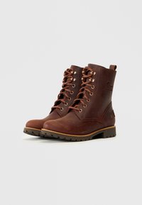 Botas de charol marrones con acabado texturizado, puntera redonda, cierre de cordones en la parte delantera, ojales de cobre y suela de goma resistente.