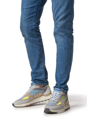 Gray and beige athletic sneakers with mesh and suede materials, featuring a textured sole, blue accents, and reflective details.