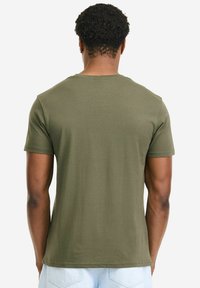 Olivgrünes Baumwoll-T-Shirt mit Rundhalsausschnitt und kurzen Ärmeln, das eine glatte Textur und eine lockere Passform aus der Rückansicht zeigt.