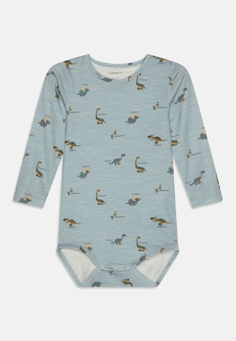Langermet baby bodysuit i lys blå, med forskjellige dinosaurtrykk. Mykt stoff, rund hals og trykknapplukking nederst.