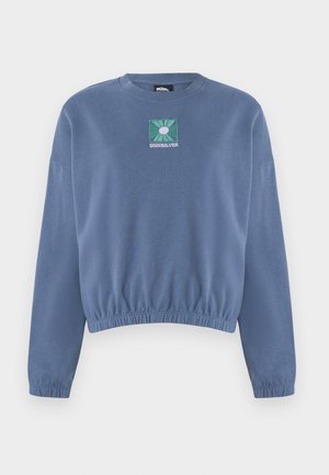 Lyseblå hettegenser med rund hals, rynket nederkant og lange ermer. Har en firkantet brodert logo med grønt og hvitt design.