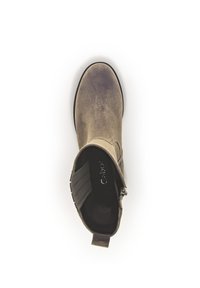 Bruine suède enkellaars met een ronde teen, elastische zijkanten en een kleine hak. Bevat een trekband voor eenvoudig aan- en uittrekken. Interieur is donker.