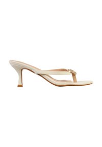 Sandale à talon en cuir beige avec bride entre les orteils et petite boucle décorative dorée sur fond blanc.